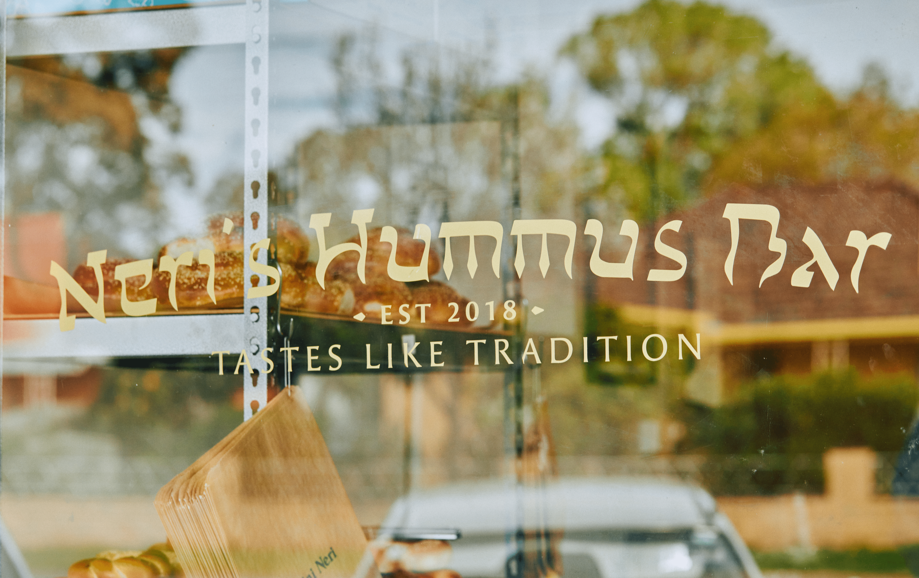 The shop front window of Neri's Hummus Bar